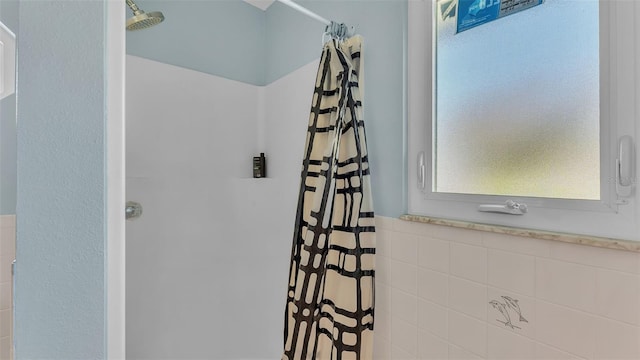 bathroom featuring tile walls and a shower with shower curtain