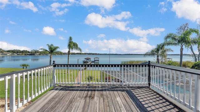 deck featuring a water view and a lawn