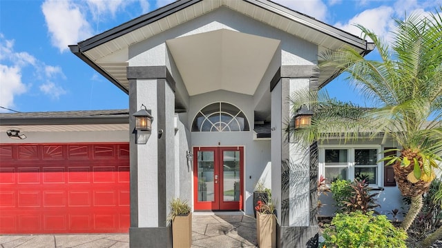 view of exterior entry with french doors and a garage