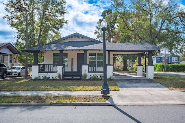 view of front of house with a carport, a porch, and a front yard