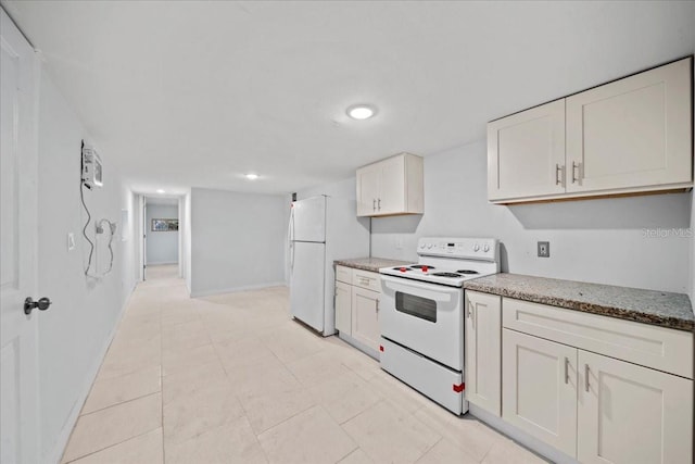 kitchen featuring white cabinets, white appliances, and dark stone countertops