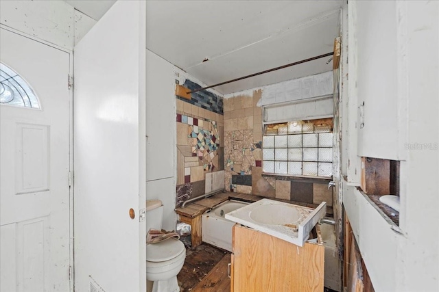 bathroom with vanity, tile walls, and toilet