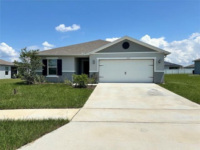 ranch-style house featuring a garage and a front lawn