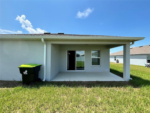 rear view of property featuring a lawn and a patio