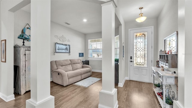 foyer with light wood-type flooring and decorative columns