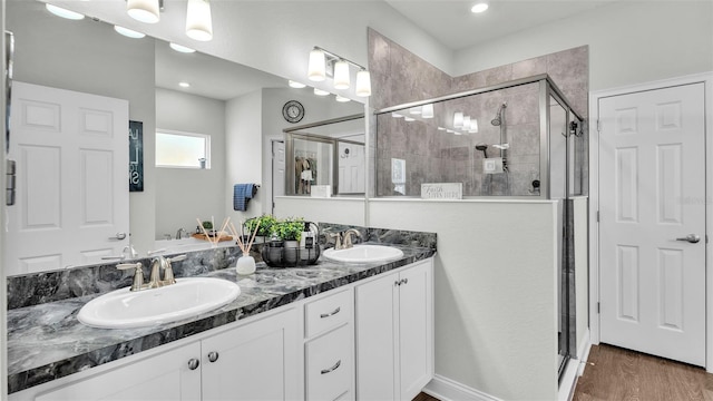 bathroom featuring vanity, wood-type flooring, and an enclosed shower