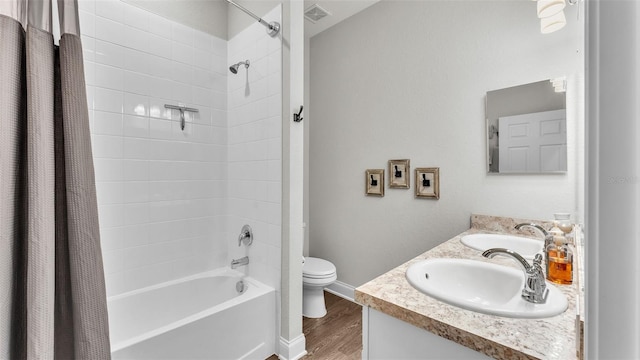 full bathroom featuring hardwood / wood-style floors, vanity, toilet, and shower / tub combo with curtain