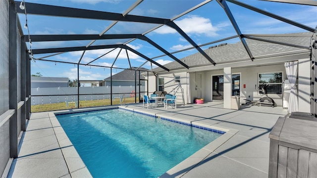 view of swimming pool featuring a patio area and a lanai