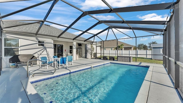 view of swimming pool with a patio area and a lanai