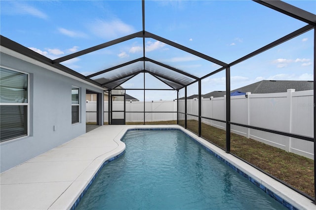 view of swimming pool featuring glass enclosure and a patio