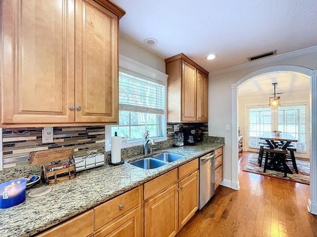 kitchen with dishwasher, backsplash, crown molding, and sink