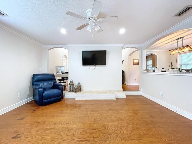 sitting room with ceiling fan, crown molding, a textured ceiling, and hardwood / wood-style flooring