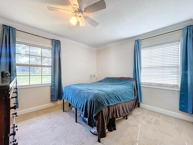 bedroom featuring a textured ceiling, ceiling fan, light colored carpet, and crown molding