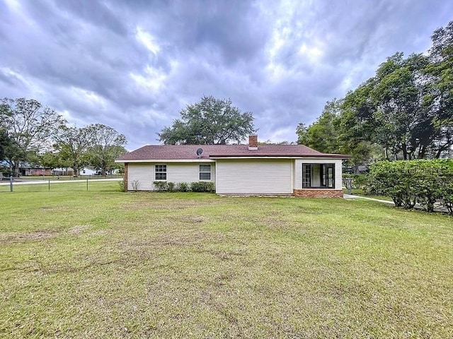 back of property featuring a yard