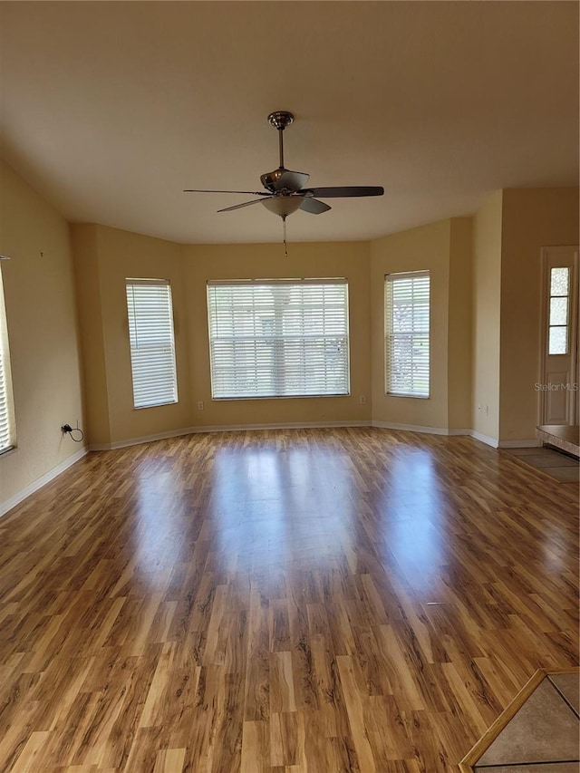 empty room with ceiling fan and wood-type flooring