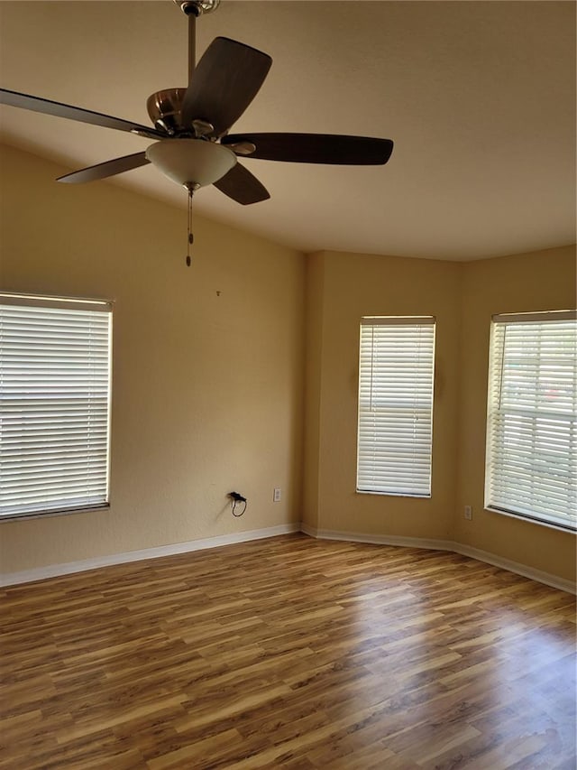 empty room with dark hardwood / wood-style floors and ceiling fan