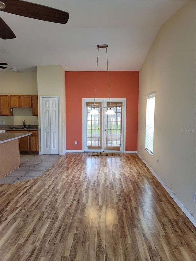 unfurnished living room featuring light hardwood / wood-style floors, ceiling fan, and lofted ceiling