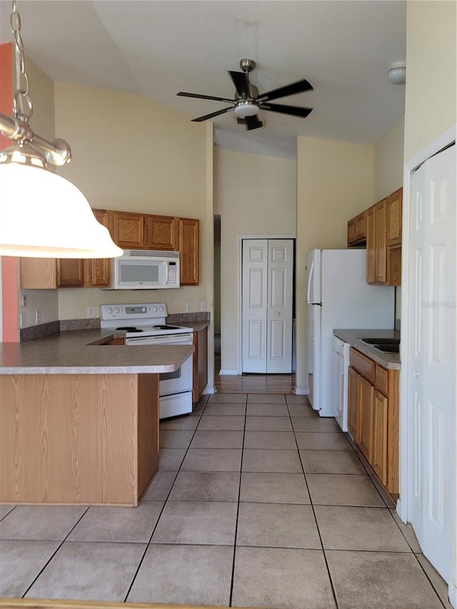 kitchen featuring white appliances, sink, ceiling fan, light tile patterned floors, and kitchen peninsula