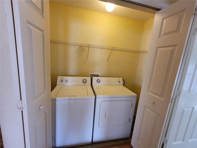 laundry room with wood-type flooring and washing machine and clothes dryer