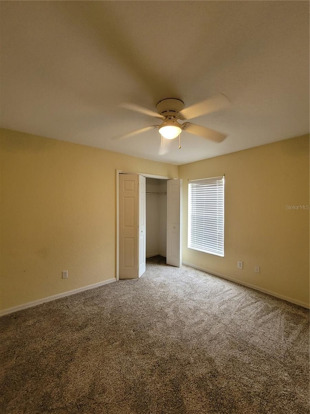 unfurnished bedroom featuring carpet flooring, ceiling fan, and a closet