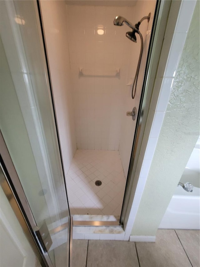 bathroom featuring tile patterned flooring and an enclosed shower