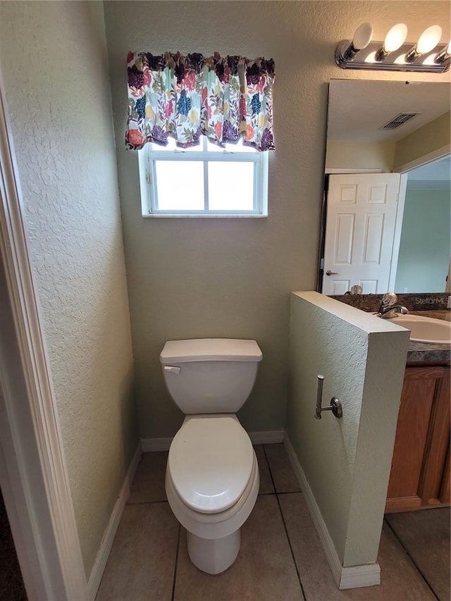 bathroom featuring tile patterned flooring, vanity, and toilet