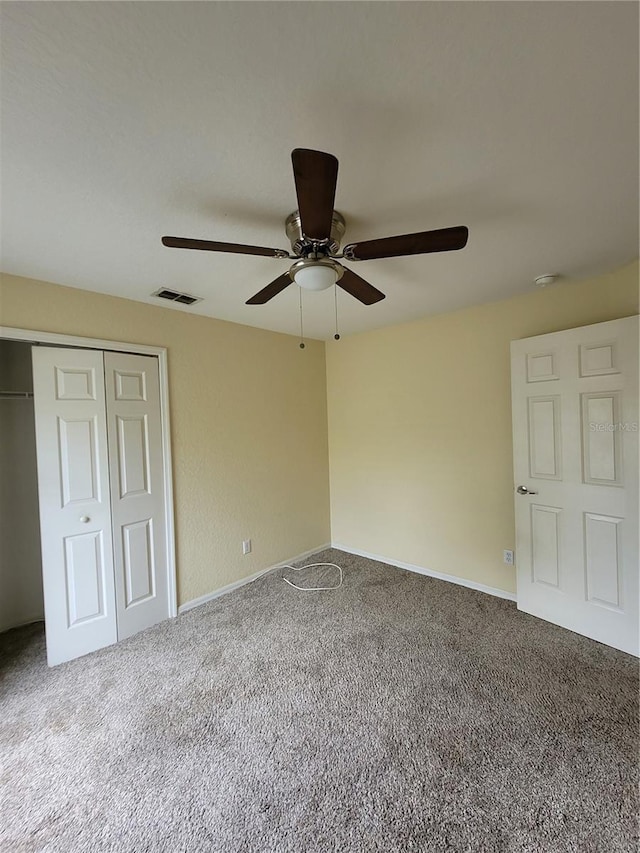 unfurnished bedroom with ceiling fan, a closet, and carpet floors