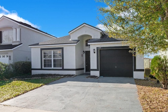 single story home with central AC unit and a garage