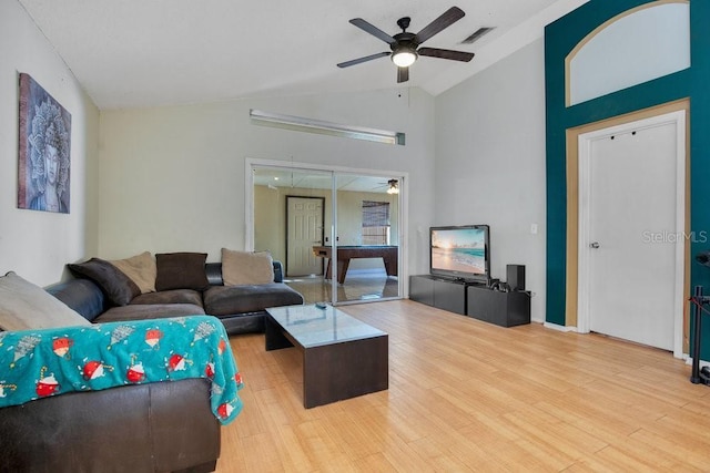 living room featuring light hardwood / wood-style floors, high vaulted ceiling, and ceiling fan