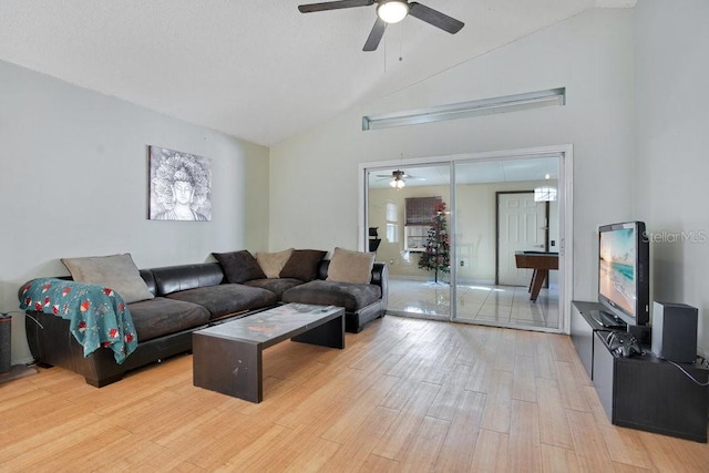 living room featuring ceiling fan, high vaulted ceiling, and light hardwood / wood-style flooring