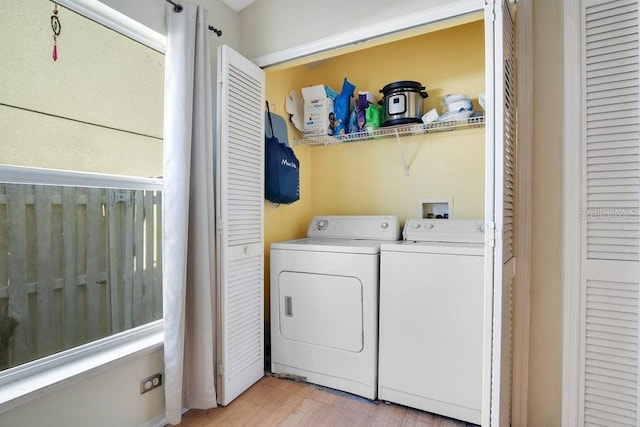 laundry room with washer and dryer and light hardwood / wood-style floors