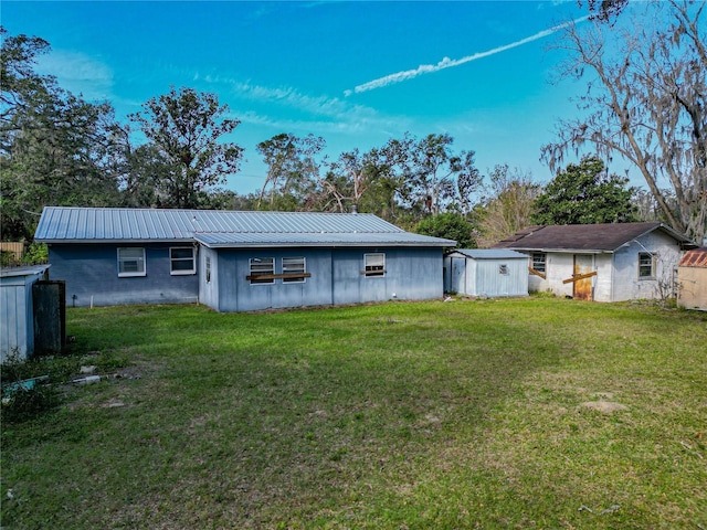 rear view of house with a yard and a storage unit