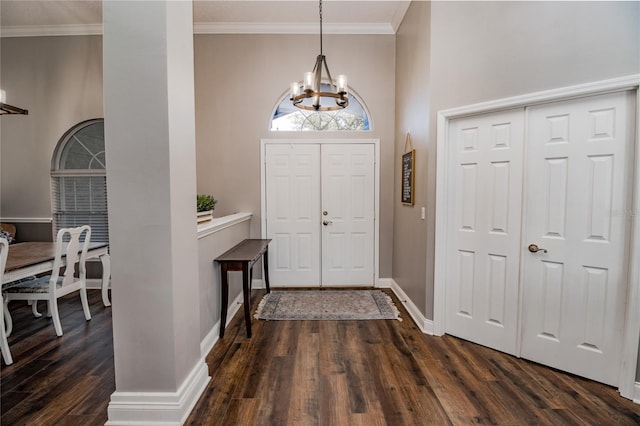 entryway featuring crown molding, a high ceiling, a chandelier, and dark hardwood / wood-style floors