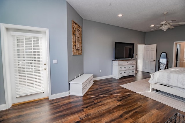 bedroom with a textured ceiling, ceiling fan, and dark wood-type flooring