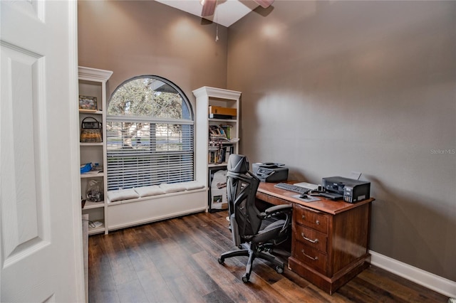 office space with ceiling fan, dark wood-type flooring, and a high ceiling