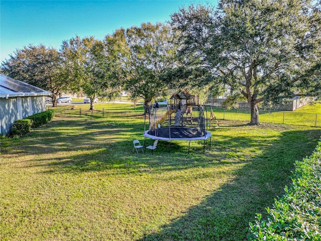 view of yard with a playground and a trampoline