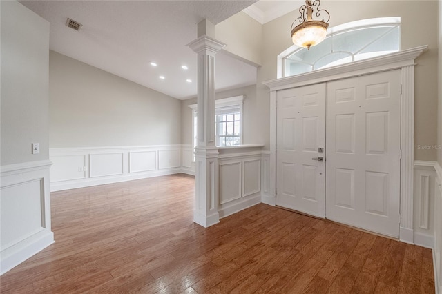 foyer entrance with decorative columns and light wood-type flooring