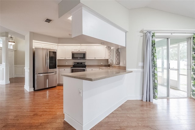 kitchen with sink, light hardwood / wood-style flooring, white cabinetry, kitchen peninsula, and stainless steel appliances