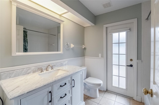 bathroom with tile patterned floors, vanity, toilet, and walk in shower