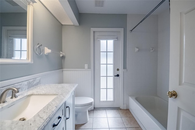 full bathroom featuring vanity, toilet, and a healthy amount of sunlight