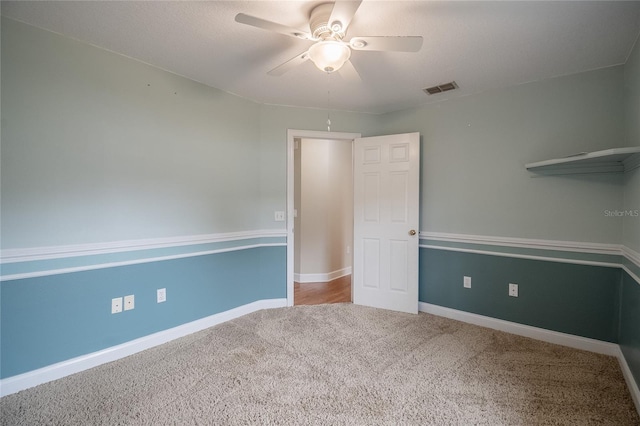 carpeted spare room with ceiling fan