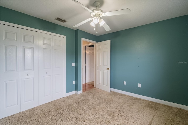 unfurnished bedroom with ceiling fan, carpet floors, and a closet