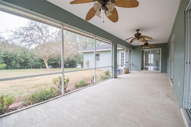 unfurnished sunroom featuring ceiling fan