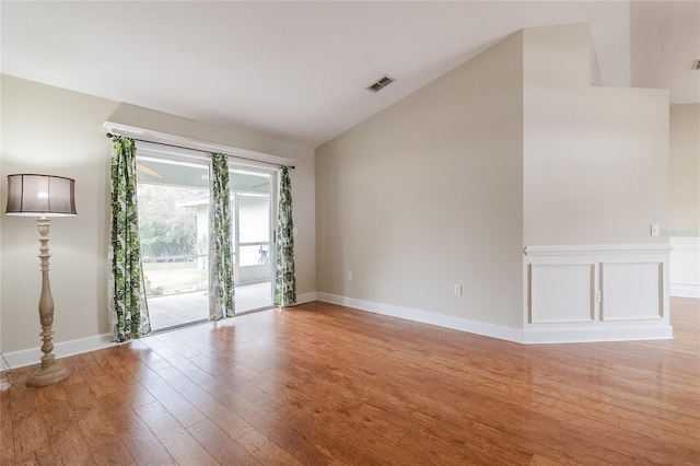 empty room featuring light wood-type flooring and lofted ceiling