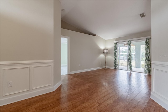 unfurnished room featuring hardwood / wood-style floors and vaulted ceiling