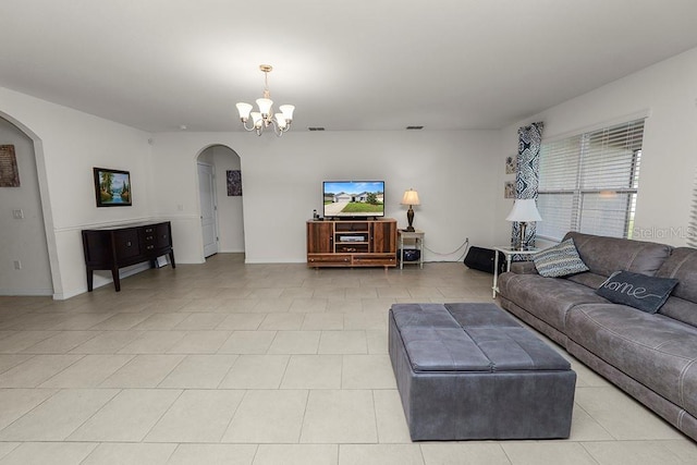 tiled living room featuring an inviting chandelier