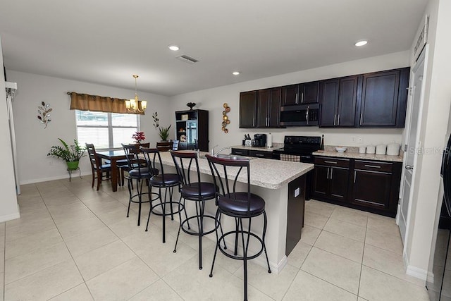 kitchen with a breakfast bar, decorative light fixtures, a center island with sink, a notable chandelier, and black electric range oven