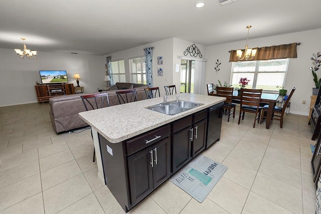 kitchen with decorative light fixtures, dishwasher, an island with sink, and a chandelier