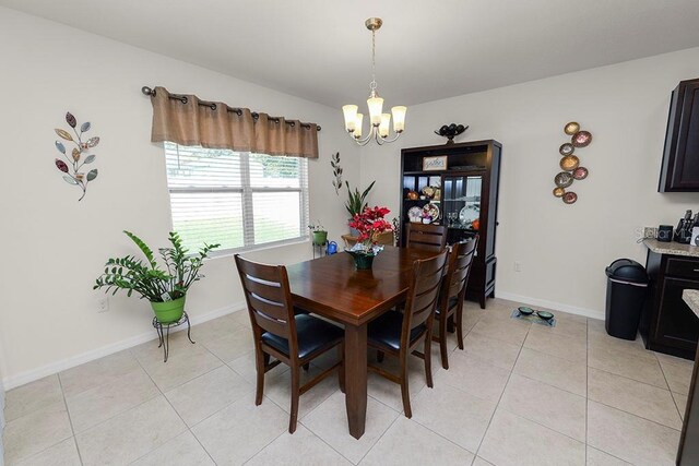 dining space with light tile patterned floors and an inviting chandelier