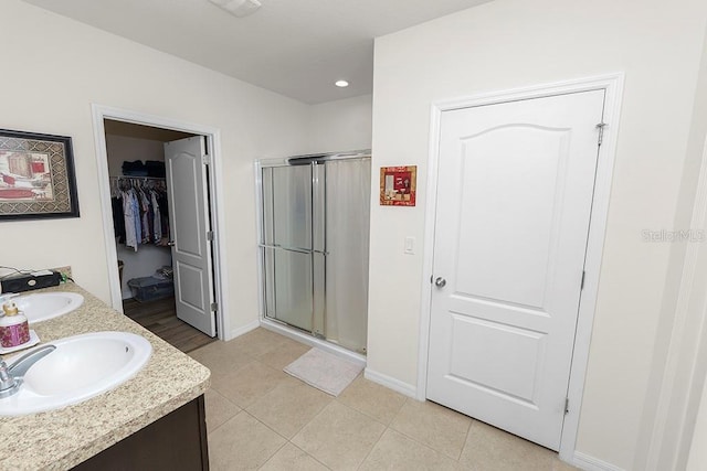 bathroom featuring tile patterned floors, vanity, and a shower with shower door